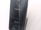 a broken samsung phone sitting on top of a stand