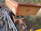 a dump truck that is parked next to a pile of wood