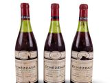 trois bouteilles de vin posées les unes à côté des autres sur une surface blanche