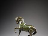 a bronze statue of a horse with a rider on its back