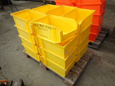 yellow and orange plastic containers stacked on a pallet in a warehouse