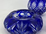 two blue glass candlesticks sitting next to each other on a white surface