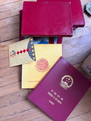 une pile de livres posée par terre à côté d'une valise
