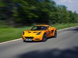 the orange sports car is driving down the road near the trees