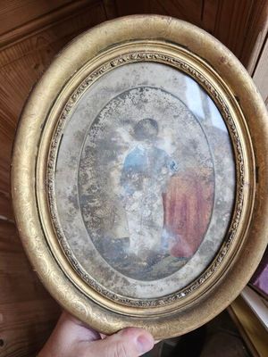 une personne tenant une photo de Jésus dans un cadre doré