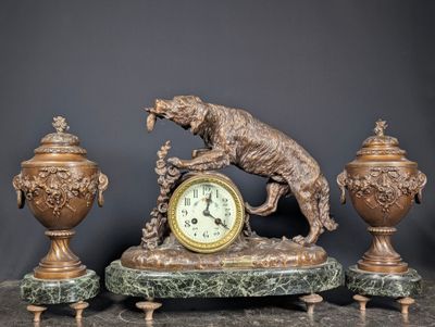 a statue of a dog on top of a clock and two vases
