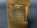 a gold cigarette case with a cigarette in it on a black surface