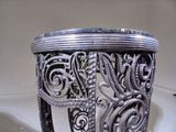 a silver vase sitting on top of a white table
