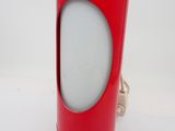 a red lamp that is on a white table