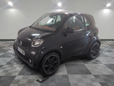 une Smart noire garée sur un sol à damier