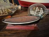 un bateau dans une bouteille posé sur une table en bois