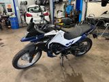 une moto bleue et blanche garée dans un garage