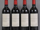 three bottles of wine are lined up on a table