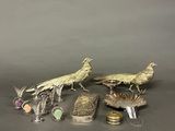 two silver birds and other silver objects on a gray surface