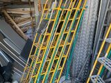 Des échelles jaunes sont empilées les unes sur les autres dans un garage.