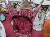 de nombreux vases de toutes sortes posés sur une table recouverte d'une nappe rouge