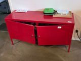 a red cabinet with two doors open in a room