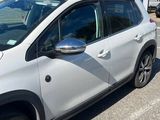 La voiture blanche est garée sur le bord de la route, dans le parking.
