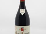 une bouteille de vin rouge posée sur une table blanche