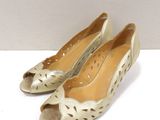 pair of women ' s gold shoes with cut outs on the toes