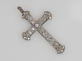 an antique diamond cross pendant on a white background