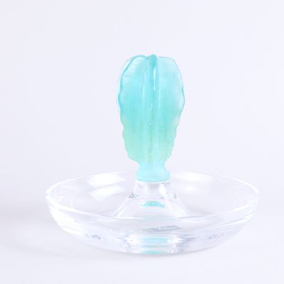 un bougeoir en verre contenant une bougie verte