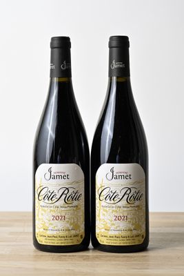 deux bouteilles de vin rouge posées l'une à côté de l'autre sur une table en bois