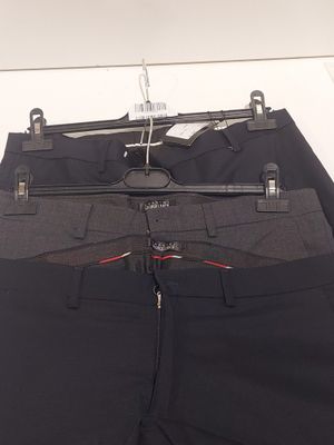 black pants hanging on a hanger on a white wall