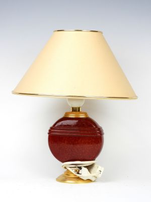 un gros plan d'une lampe posée sur une surface blanche, avec un abat-jour beige
