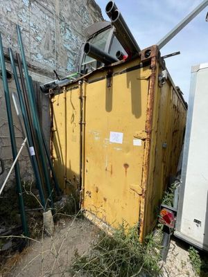 une benne à ordures posée à côté d'un immeuble