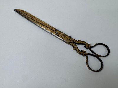 a pair of scissors on a table with a white background
