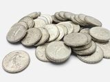 une pile de pièces d'argent sur une surface blanche