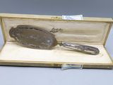 an antique silver plated mirror in a wooden box with a silver handle