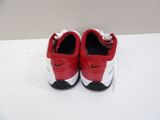 red and white nike shoes with black soles on a white surface