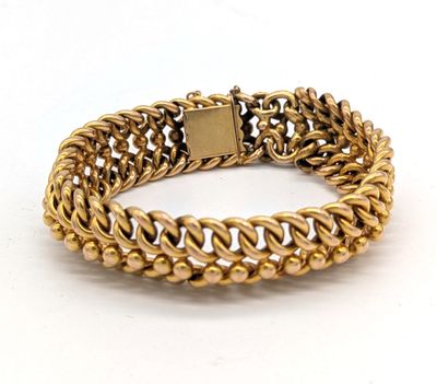 gros plan d'un bracelet en or sur fond blanc