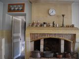 a fireplace in a kitchen with pots and pans on the mantle