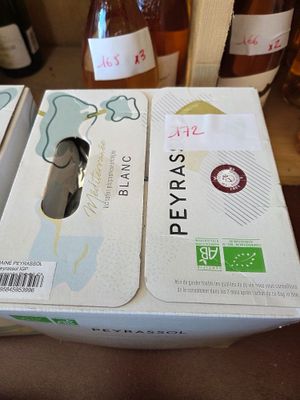 two boxes of wine sitting on a table with a bottle of wine in the background
