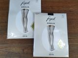 Deux paires de collants blancs sont posées sur un parquet.