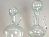 two glass vases sitting next to each other on a table