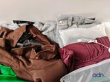 a suitcase full of clothes sitting on a bed