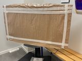 un banc en bois dans une pièce, sur lequel est posé un morceau de carton