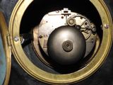 a close up of a clock with a metal ball inside of it