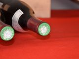 two bottles of wine sitting on a red cloth