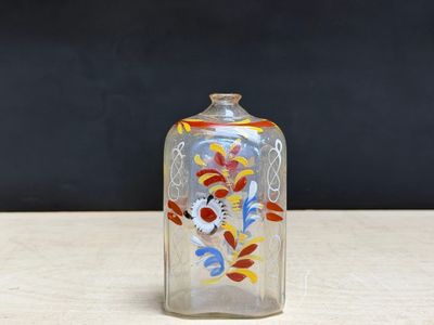 a small glass bottle with a colorful design on it