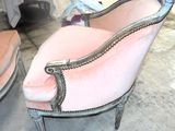 une chaise rose qui se trouve dans une pièce