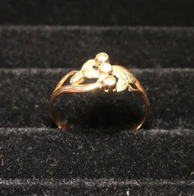 une bague en or sur laquelle est représenté un singe, sur un fond noir