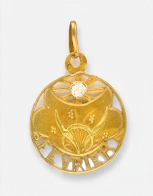 un gros plan d'un pendentif en or orné d'une fleur