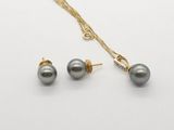 a necklace and earring set with grey pearls on a white background