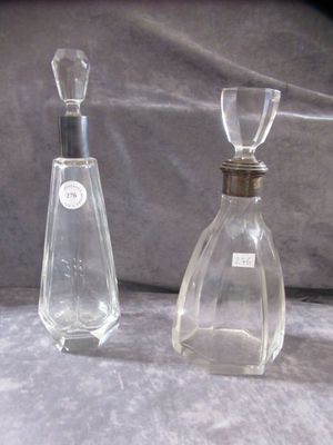 two bottles of perfume sitting next to each other on a table