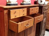 a wooden cabinet with two drawers and two vases on top of it